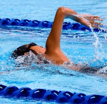 Nadador practicando crol en una piscina